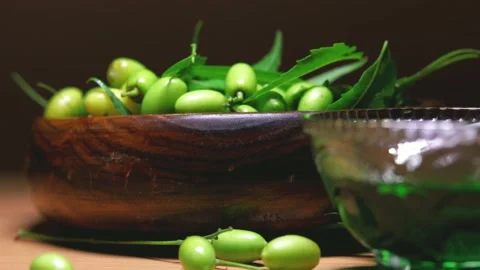 Natural neem fruit and leafs in wooden bowl and spoon,neem family, ayurveda Ayur Stock Footage 135740432