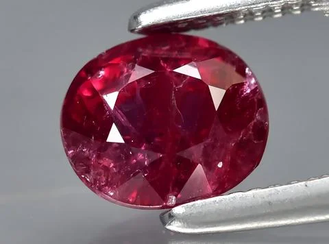 Natural pink red ruby gem on the background Stock Photos