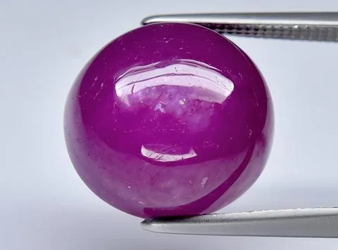 Natural pink red ruby gem on the background Stock Photos