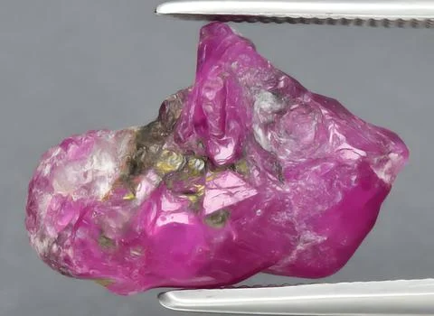 Natural pink ruby rough gem on the background Stock Photos