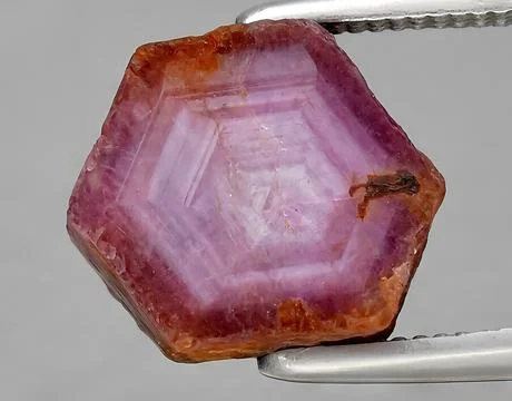 Natural pink ruby rough gem on the background Stock Photos
