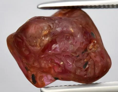 Natural pink ruby rough gem on the background Stock Photos