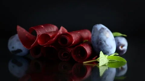 Natural plum fruit leather with ripe plum on dark background Stock Footage 346547779