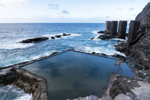Natural pool reflecting cloudy sky near the ocean in tenerife, spain Stock Photos