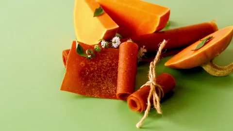 Natural pumpkin fruit rolls decorated with herbs on green background 스톡 동영상 346547944