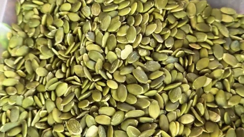 Natural pumpkin seeds in transparent container with fresh organic texture and Stock Footage 345724859