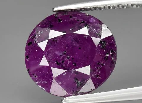 Natural purple ruby rough gem on the background Stock Photos