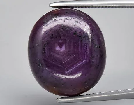 Natural purple ruby rough gem on the background Stock Photos