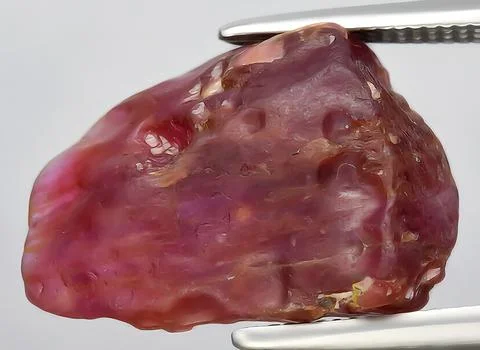 Natural red ruby rough gem on the background Stock Photos