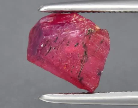 Natural red ruby rough gem on the background Stock Photos