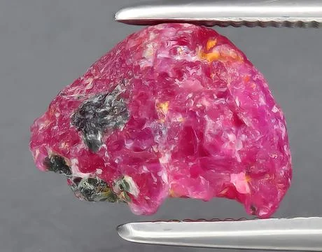 Natural red ruby rough gem on the background Stock Photos