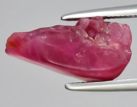 Natural red ruby rough gem on the background Stock Photos