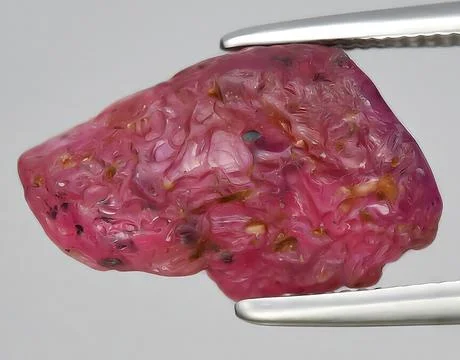 Natural red ruby rough gem on the background Stock Photos