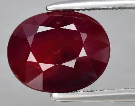 Natural red ruby rough gem on the background Stock Photos