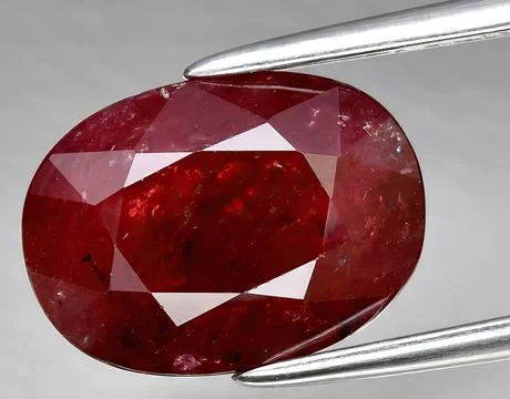 Natural red ruby rough gem on the background Stock Photos