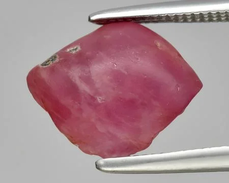 Natural red ruby rough gem on the background Stock Photos
