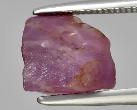 Natural red ruby rough gem on the background Stock Photos