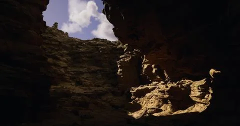 Natural rock formations create dramatic light in a canyon at midday Stock Illustration