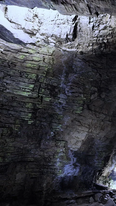 Natural rock formations inside a cave with light shining through cracks Stock Footage 331709579