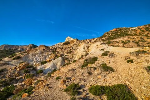 Natural rock formations of yellow cliffs on low sunlight, Milos, Greece. Weather Stock Photos