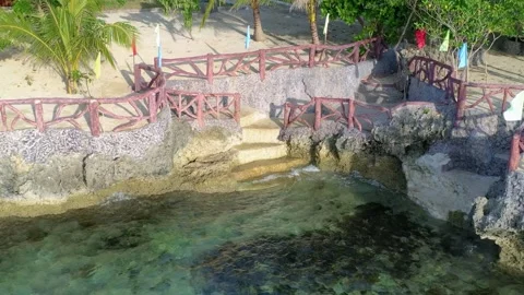 Natural rock pool with stone steps and wooden footbridge Stock Footage 327551213