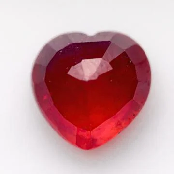 Natural ruby in the shape of a heart on a white background Stock Photos