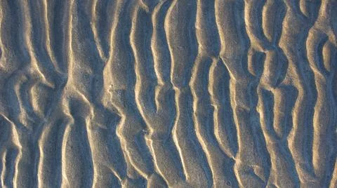 Natural sand pattern on flat sandy beach during low tide. Photos
