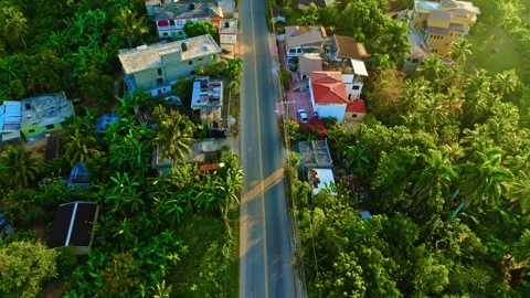 Natural scenery with a road through a small town with tropical forest. Video stock 332658901