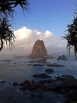 Natural sea stack rises from deep blue waters Stock Photos