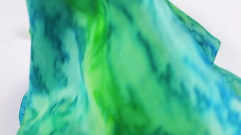 Natural silk fabric gently falls onto a clean white background in slow motion.  Vidéo 337404257