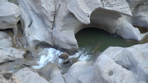 Natural small waterfall with crystal clear water between old stones in spring. Stock Footage 99867544