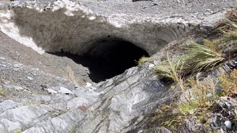 Natural snow cave over an alpine stream in Mount Aspiring National Park, New Stock Footage 343840312