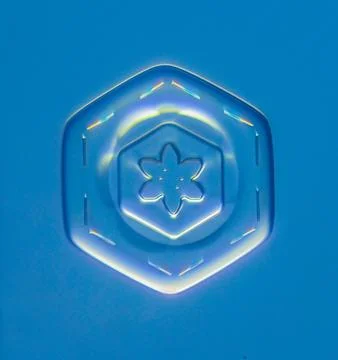 Natural snowflake crystal in blue background Stock Photos