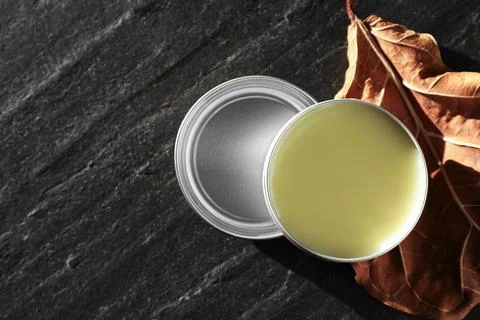 Natural solid perfume and dry leaf on black table, top view. Space for text Foto stock