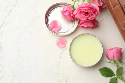 Natural solid perfume and pink roses on white textured background, flat lay.. Stock Photos