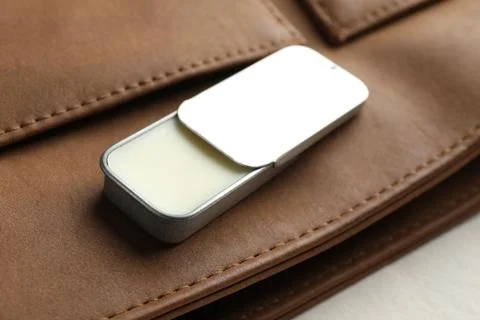 Natural solid perfume in container and leather bag on light table, closeup Foto stock