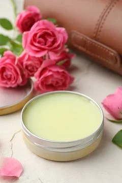 Natural solid perfume in container and pink roses on white table, closeup Stock Photos