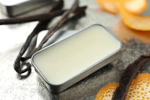 Natural solid perfume in container, vanilla pods and orange peels on grey t.. Stock Photos