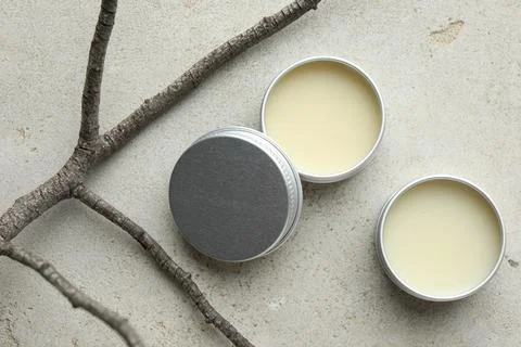 Natural solid perfume in containers and dry twigs on light table, flat lay Foto stock