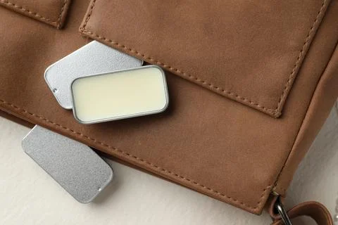 Natural solid perfume in containers and leather bag on light table, flat lay Stock Photos