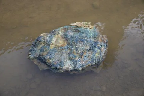 Natural stone with multple colors inside water pond Stock Photos
