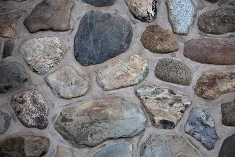 Natural stone wall with mortar, rustic field stone masonry texture background Stock Photos
