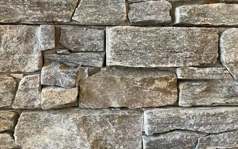 Natural stone wall texture background architectural detail close-up. Stock Photos