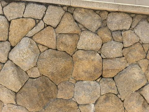Natural stone wall texture with irregular shapes and warm earthy tones Stock Photos