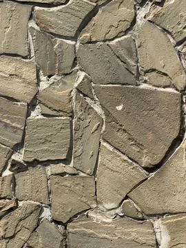 Natural stone wall texture with irregular, rough-cut blocks Stock Photos