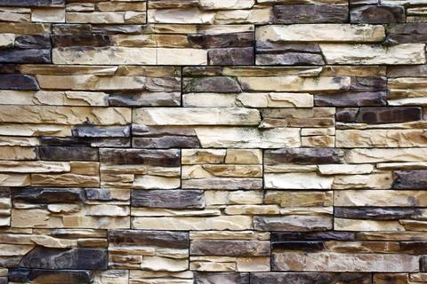 Natural stone wall texture with various rectangular blocks in beige Stock Photos