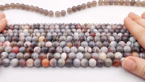 Natural striped agate gemstone round beads polished for jewelry design projects Stock Footage 345139642
