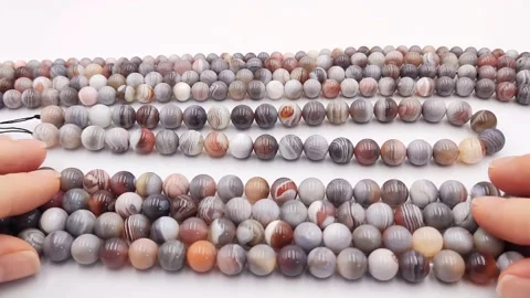 Natural striped agate gemstone round beads polished for jewelry design projects Stock Footage 345139649