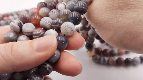Natural striped agate gemstone round beads polished for jewelry design projects Stock Footage 345139665