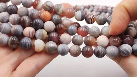 Natural striped agate gemstone round beads polished for jewelry design projects Stock Footage 345139669